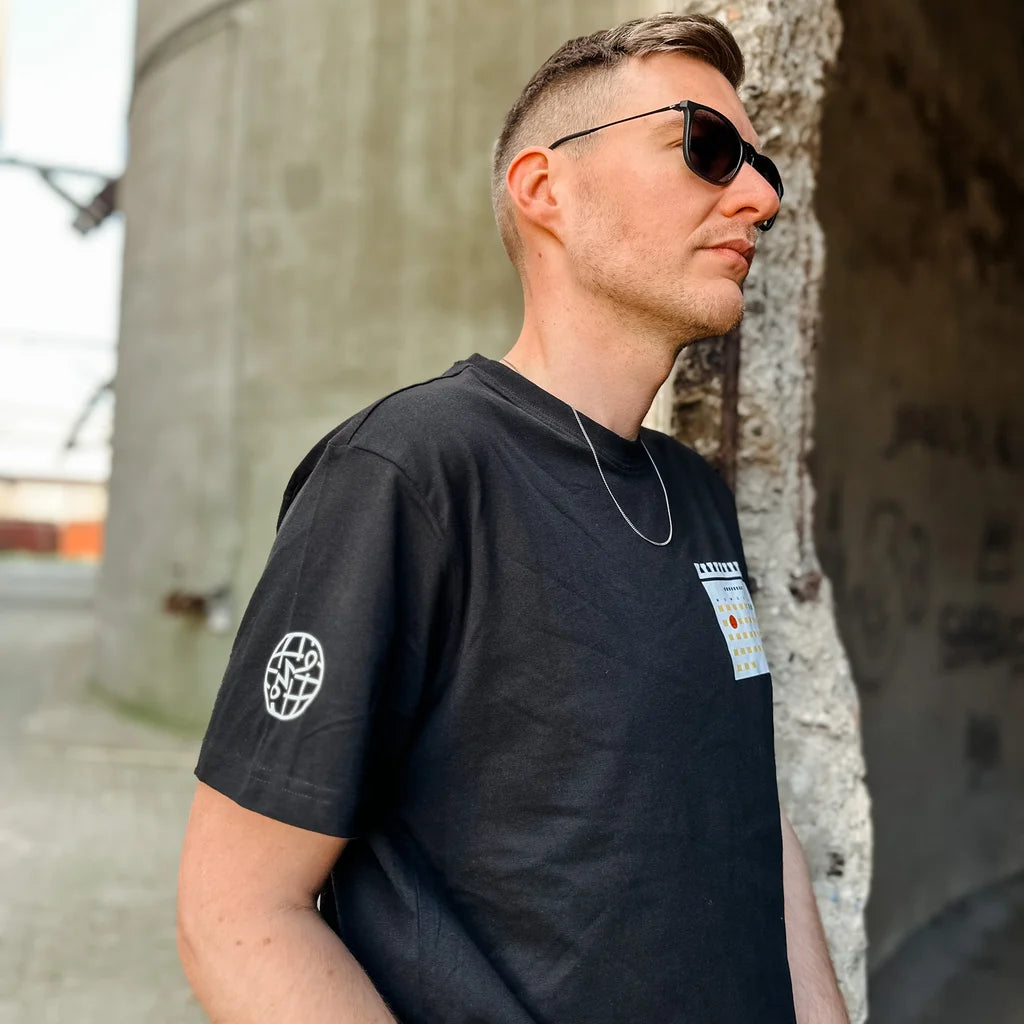 Zwart T-shirt met een kalender print van dinsdagdip op borst en logo van SNIVV op de mouw. Leuke en grappige kleding voor festivals.